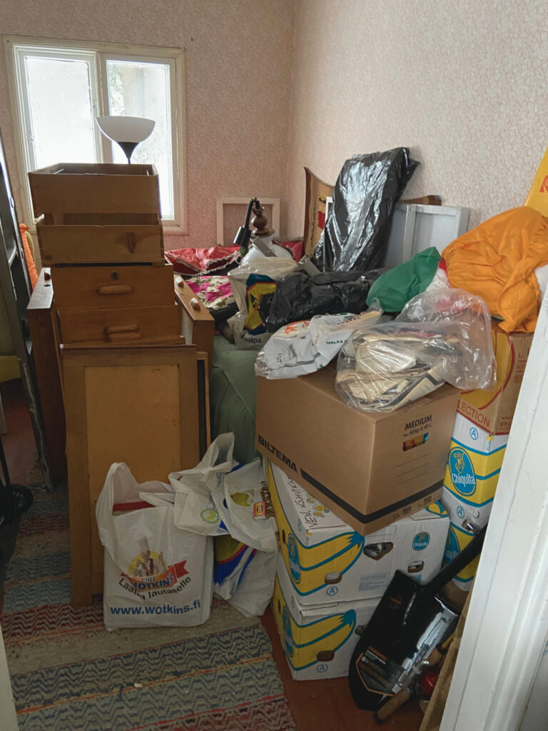Cottage bedroom filled with boxes before the clean-out and renovation began.